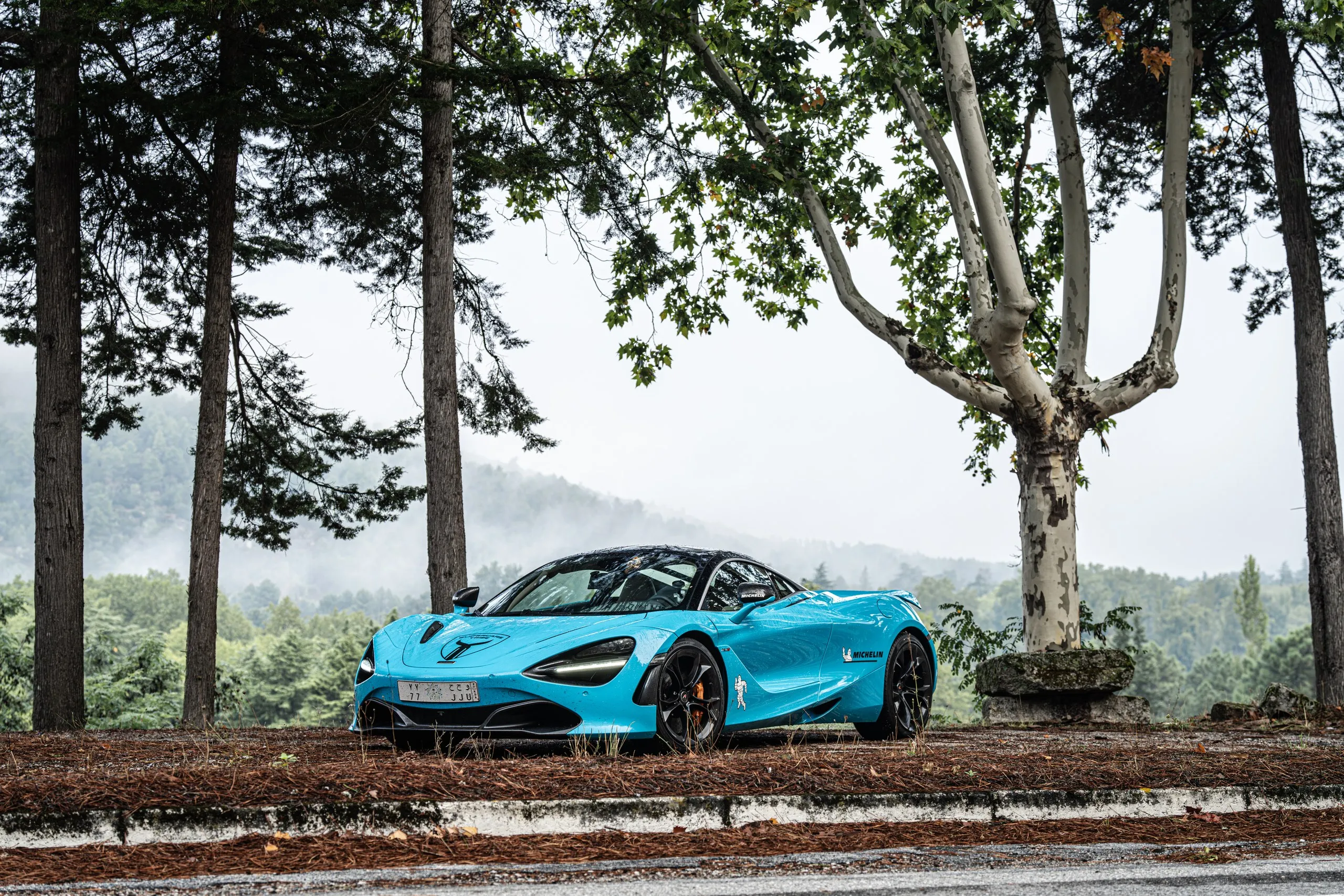 Teal sports car on a coastal road