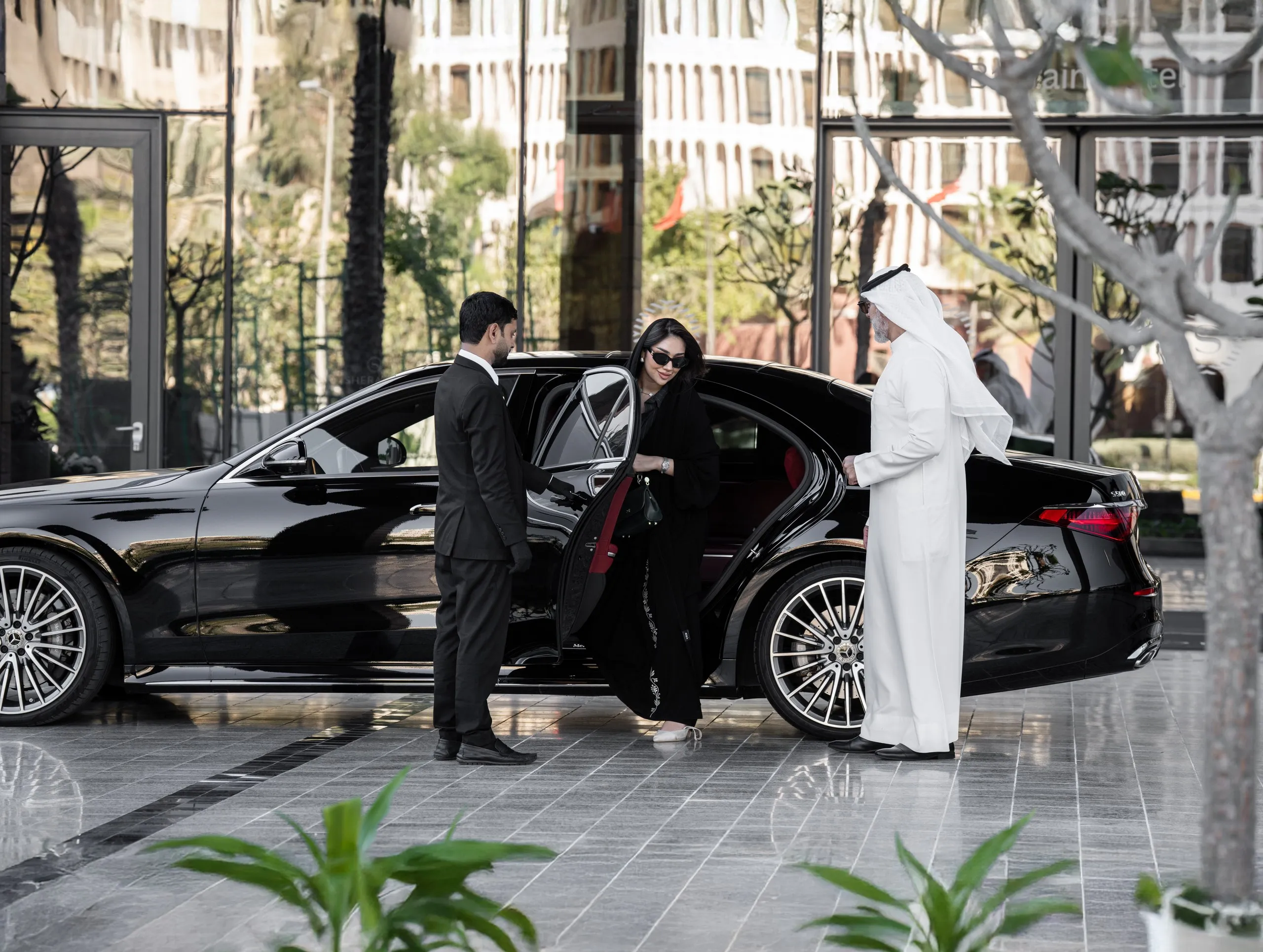 Chauffeur opening the door of a black car
