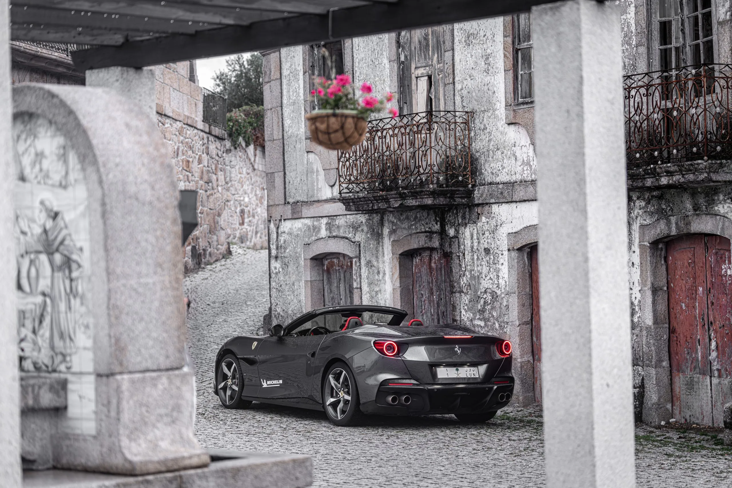 Sports car parked beside a weathered facade