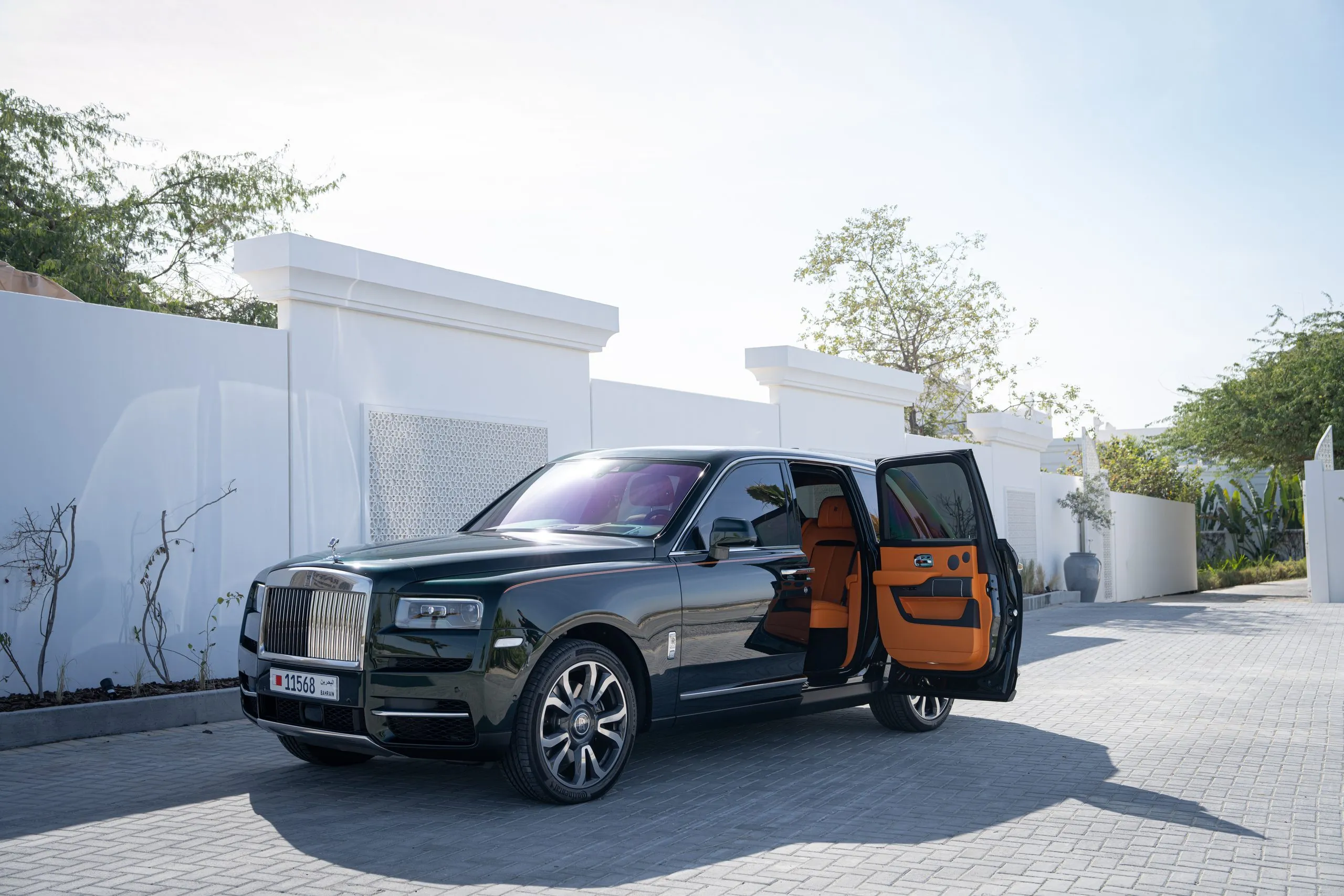Rolls-Royce with its doors open, escort car behind