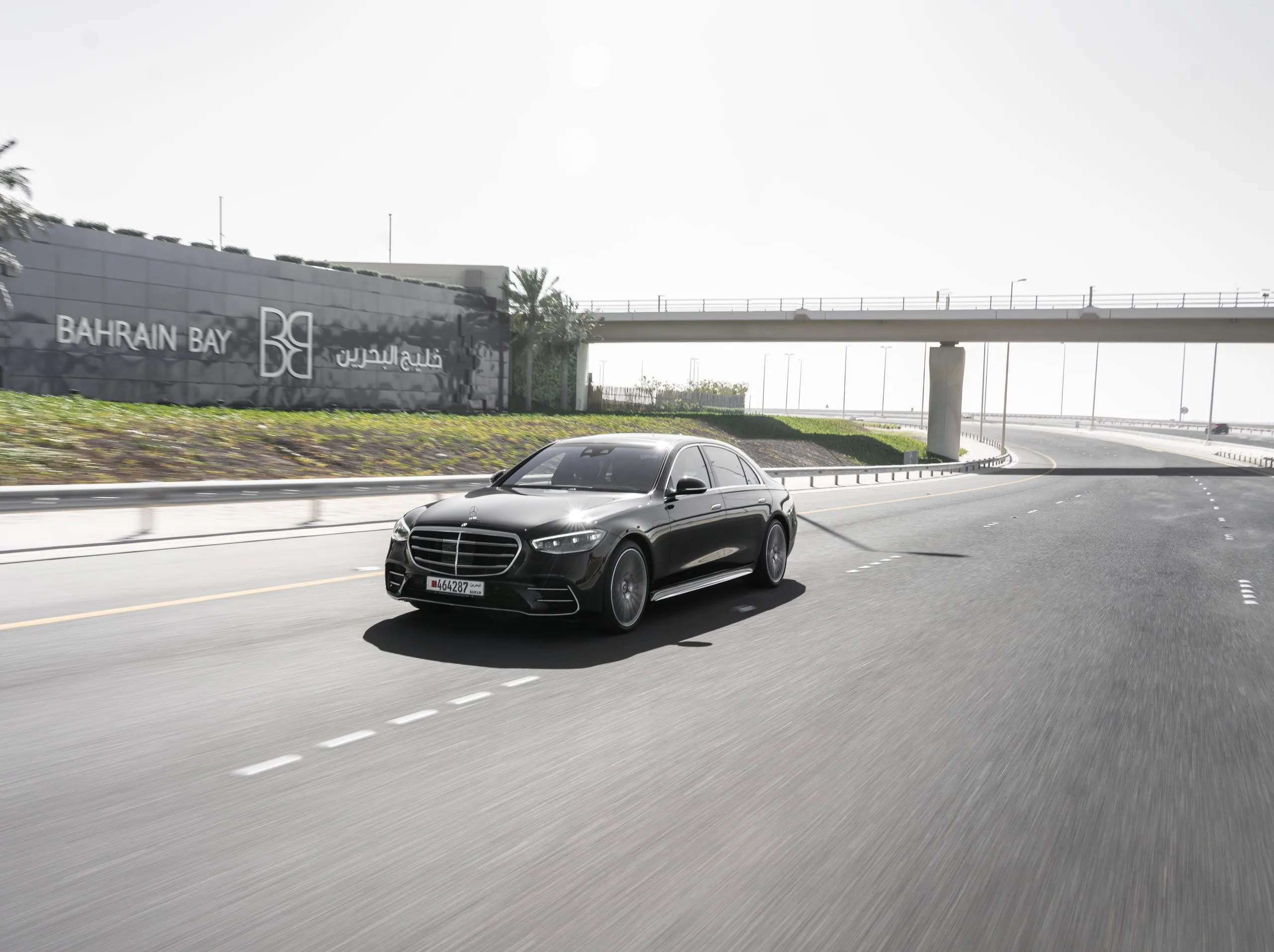 Black sedan crossing an overpass