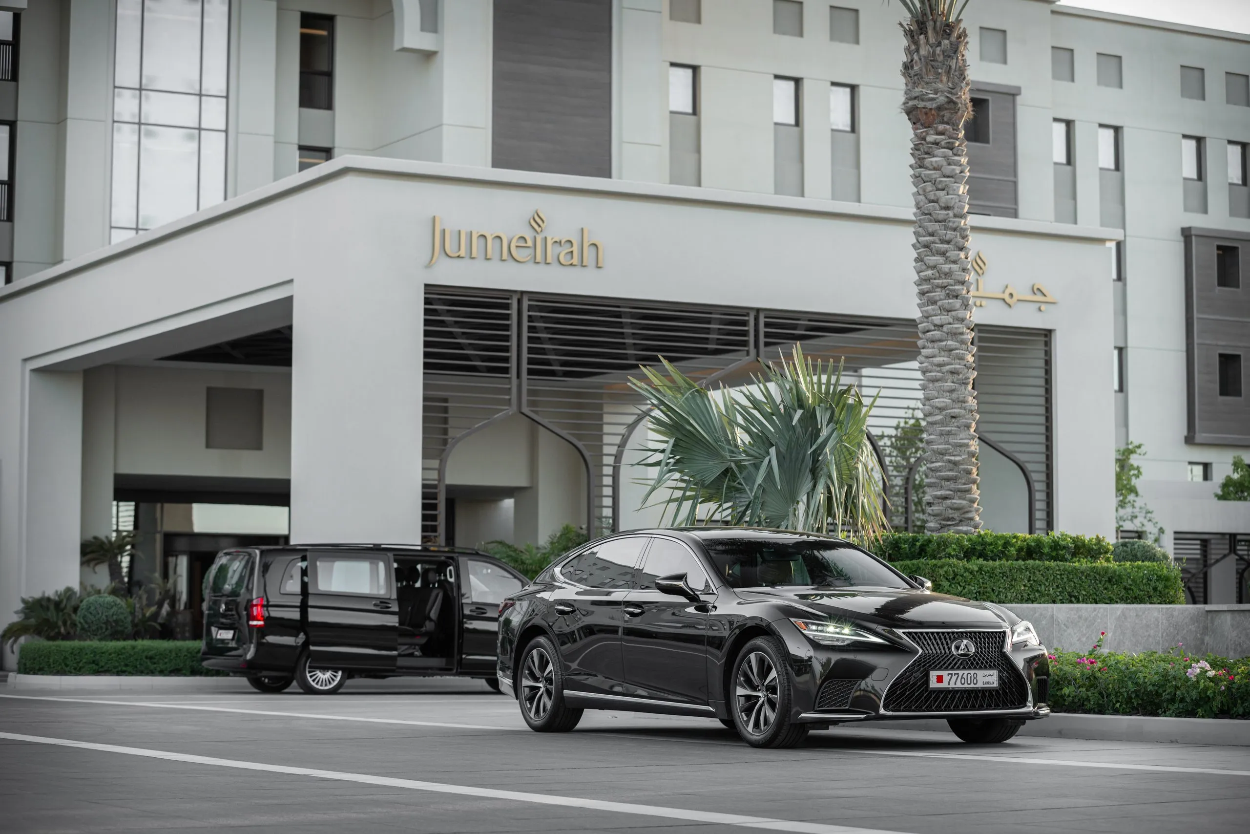 Cars staged outside a hotel entrance at dusk