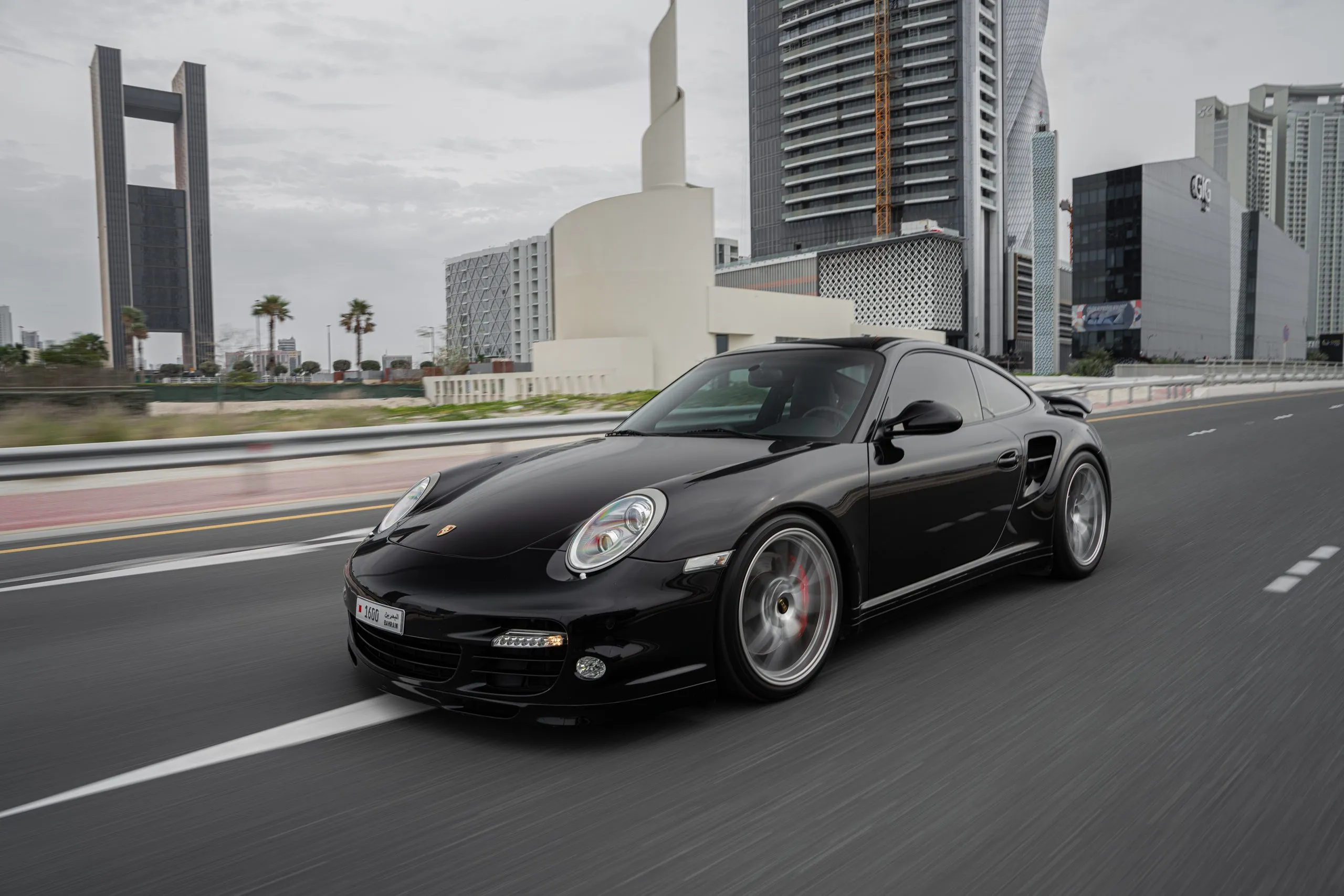 Black Porsche 911 Turbo on a coastal highway