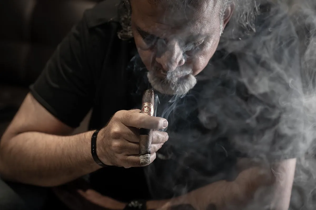 Man exhaling cigar smoke