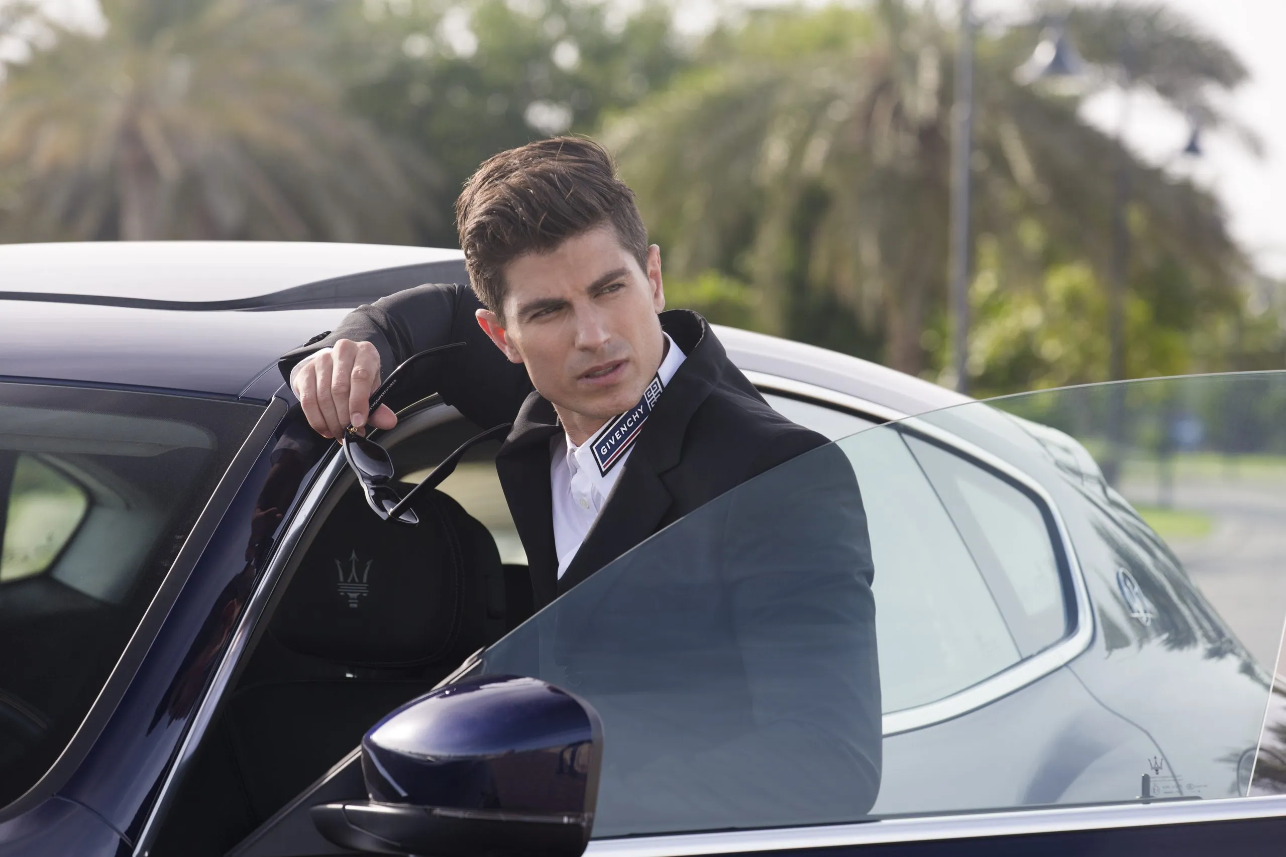 Man leaning from the door of a luxury car