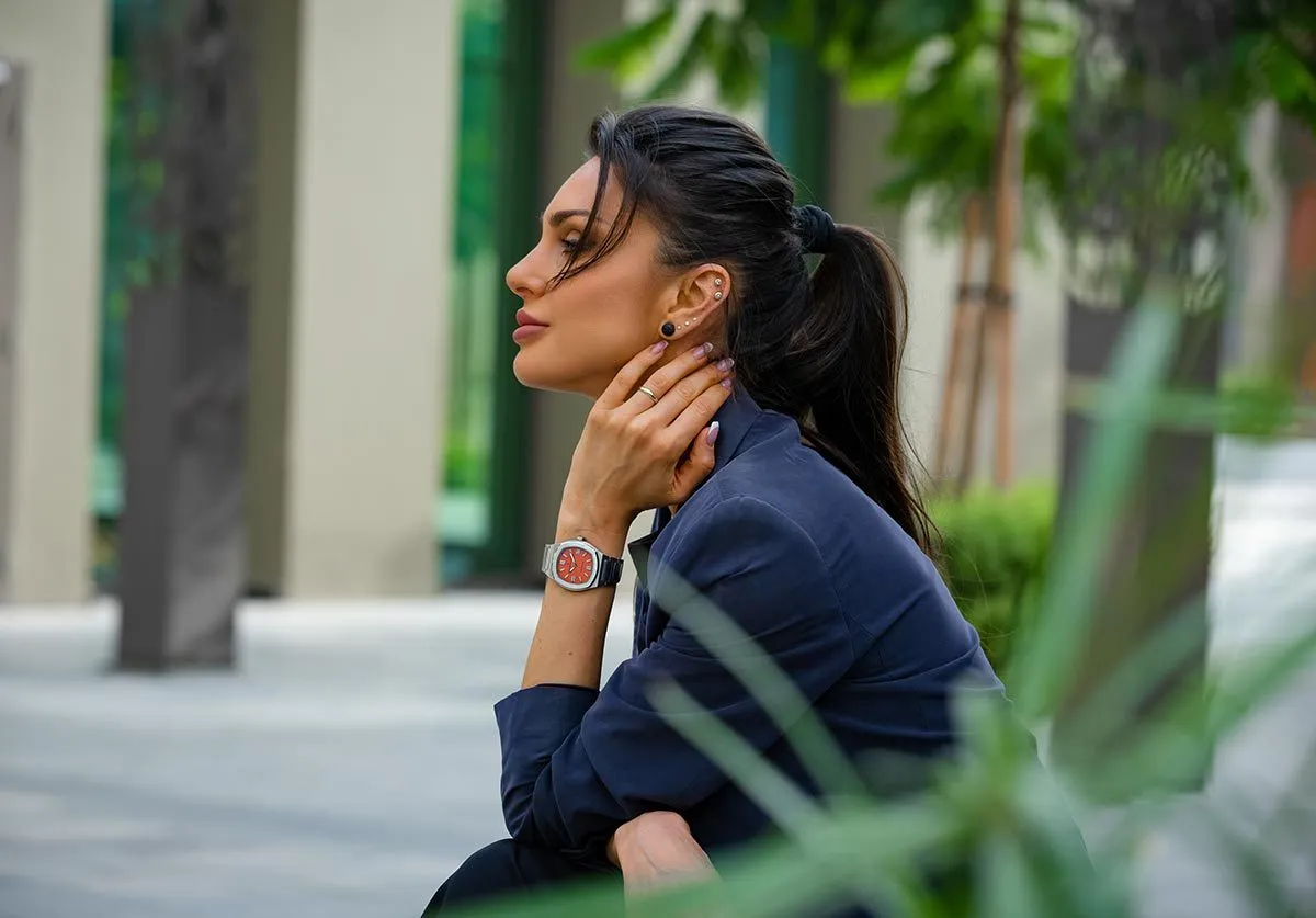 Profile of a woman in a dark blazer among palms