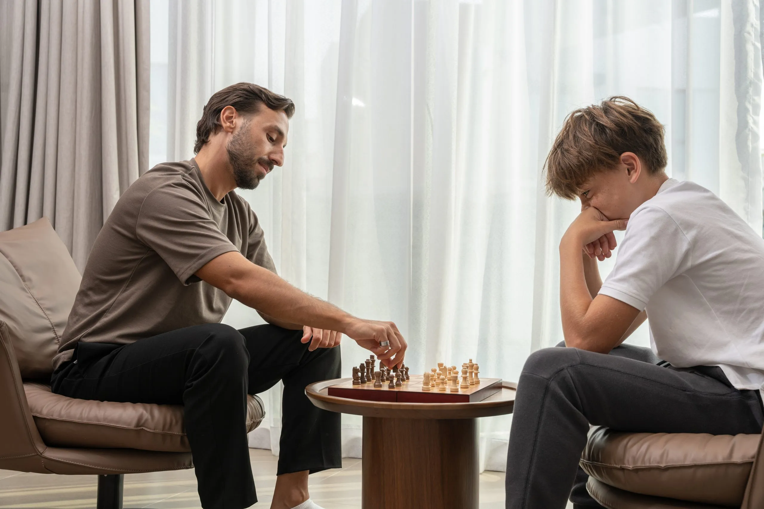 Two men playing chess in a living room