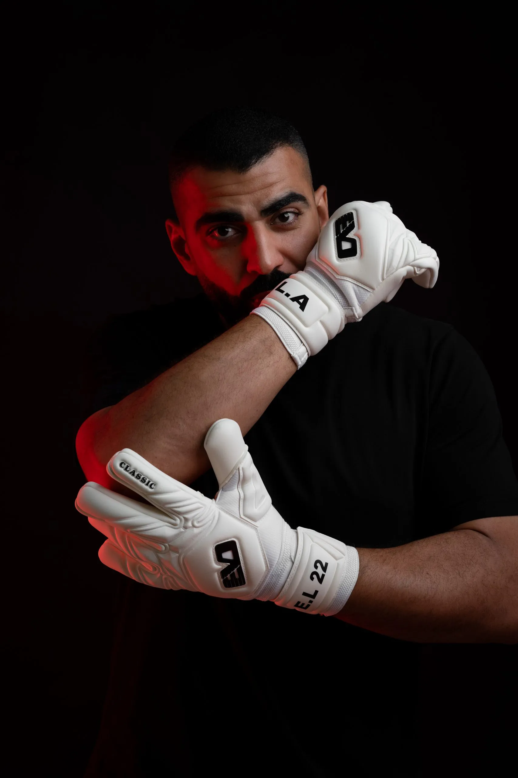 Crossed hands in white and red goalkeeper gloves