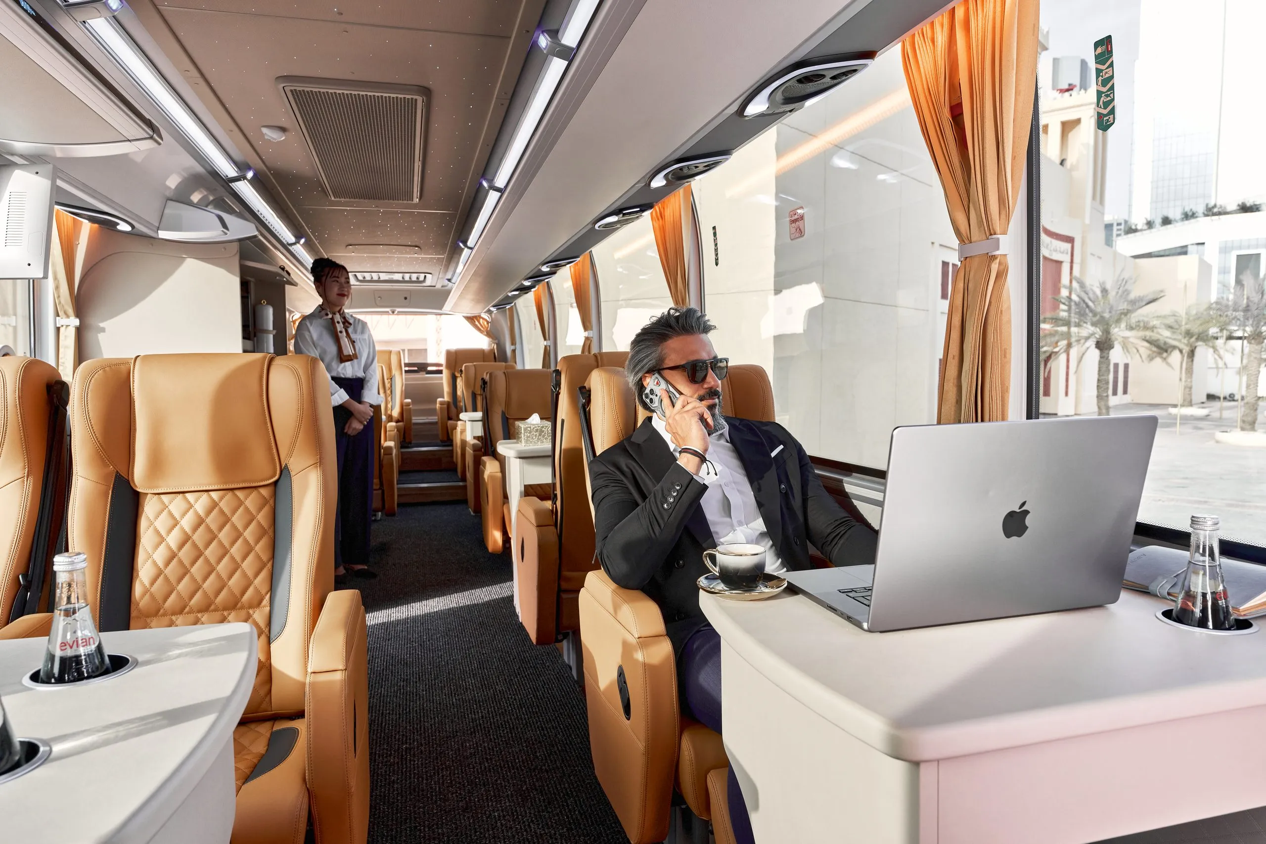 Passenger working on a laptop in a luxury coach