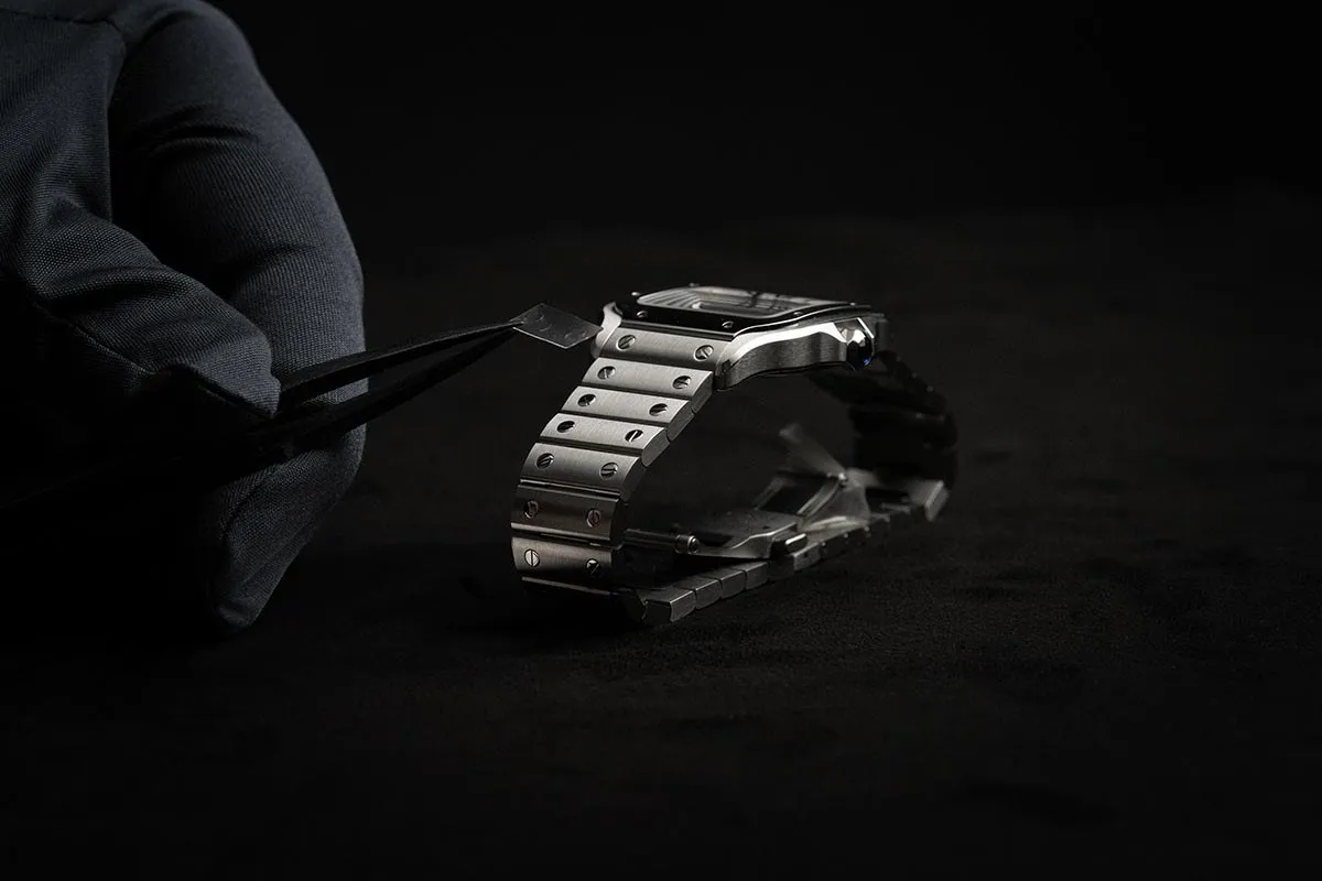Stainless steel watch lit dramatically on black
