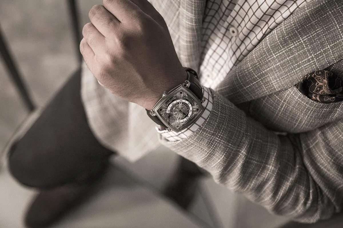 Silver chronograph on the wrist of a man in a cream knit
