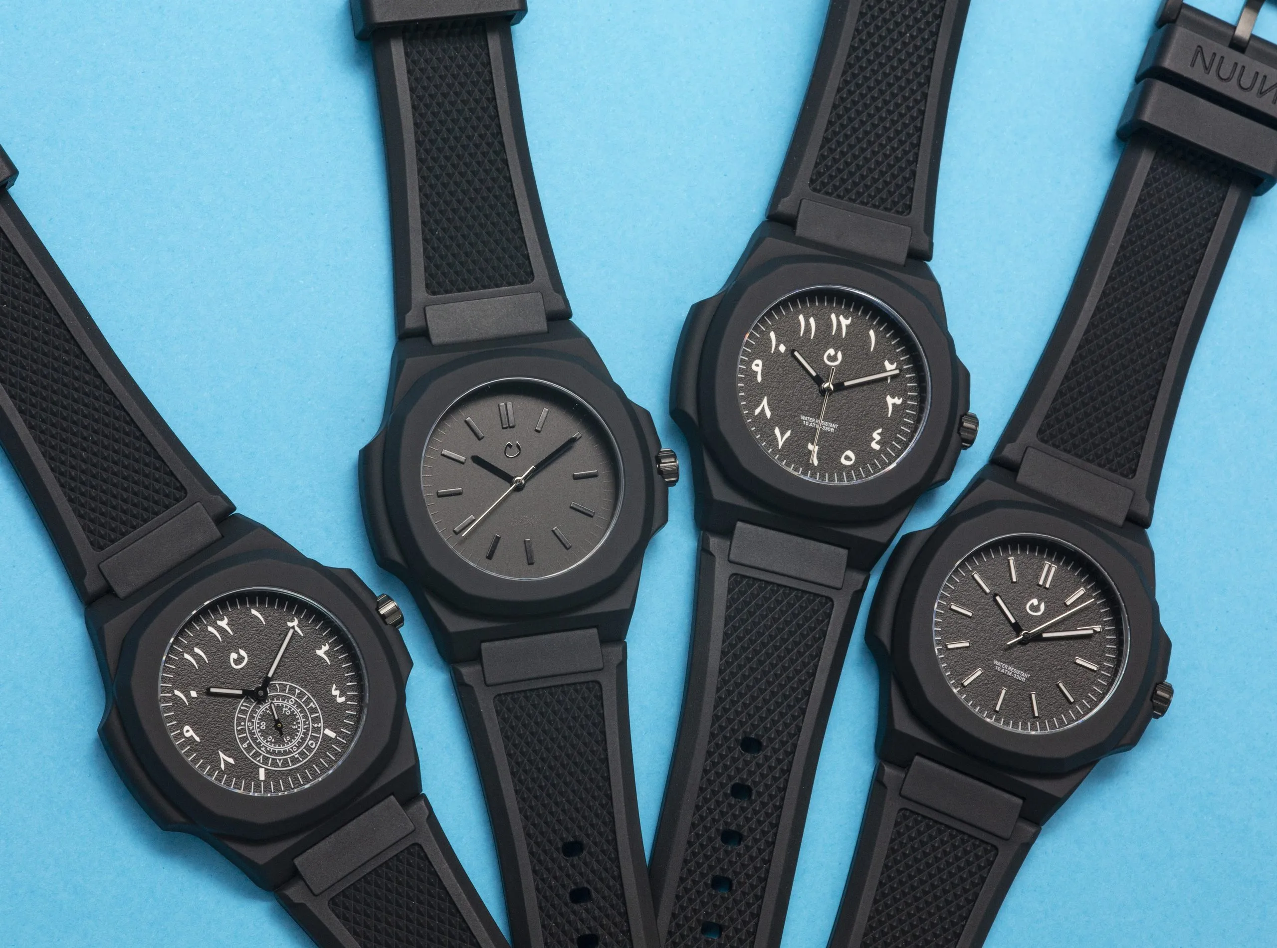 Flat lay of five black watches on a blue background