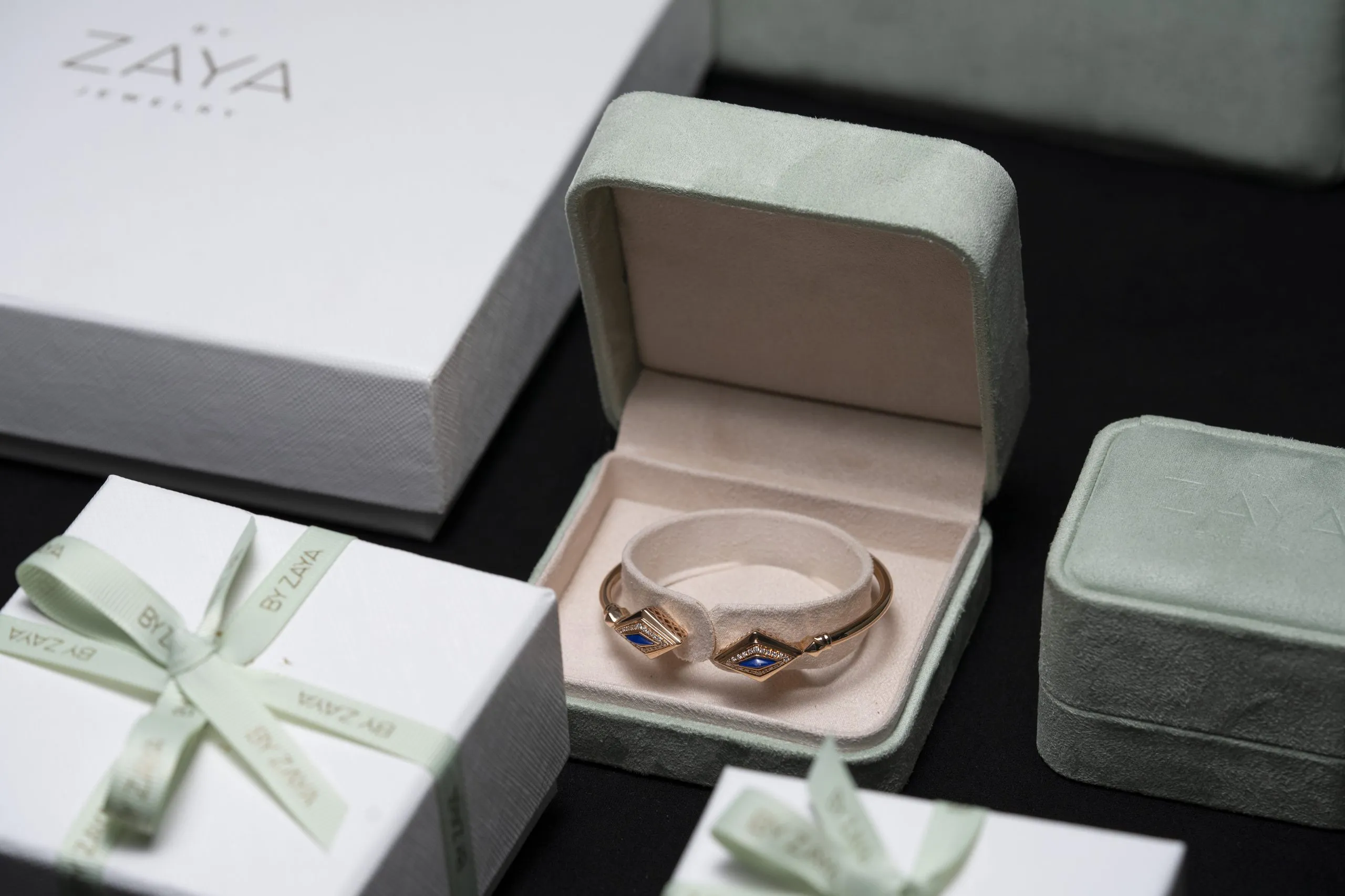 Ring in a presentation box among green gift boxes