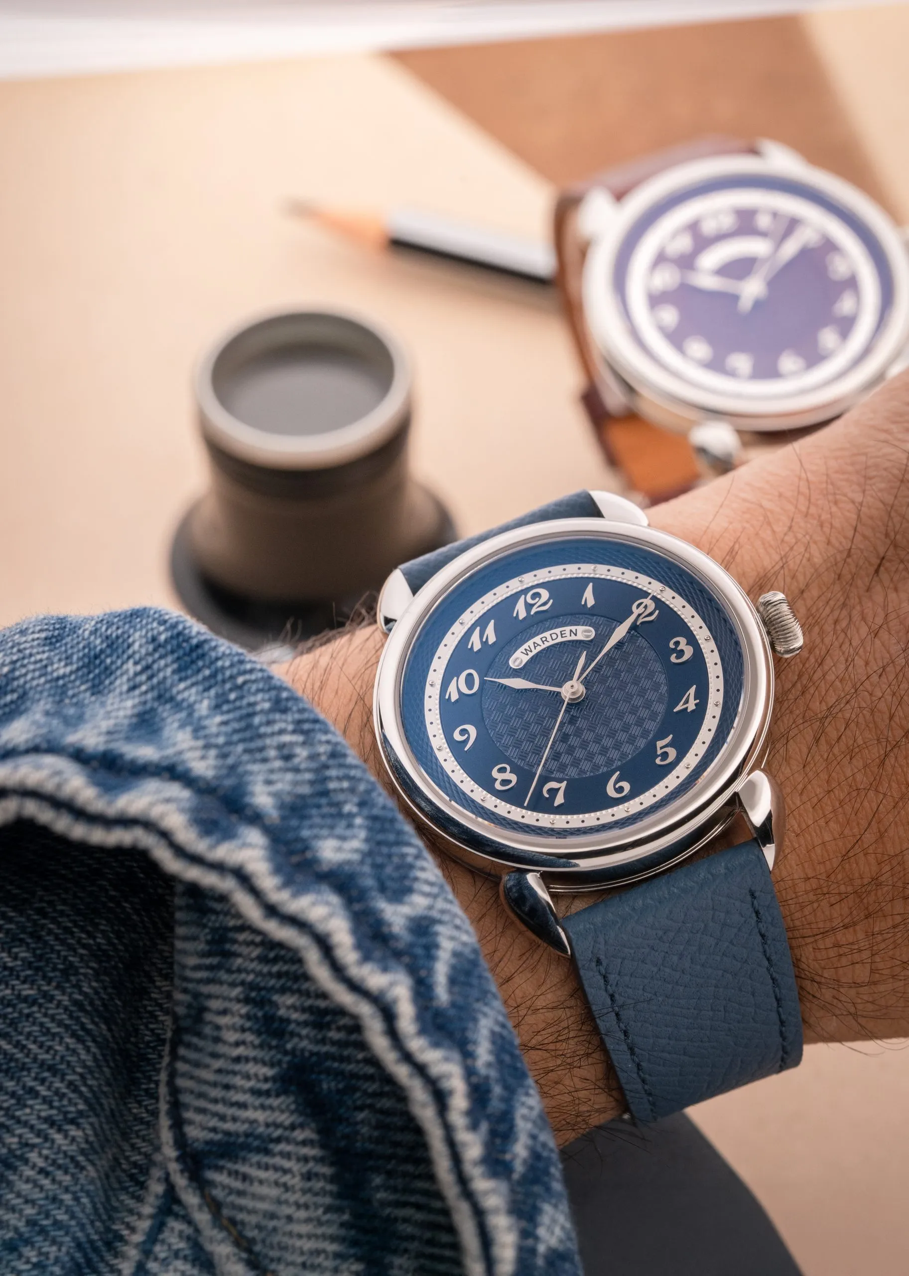 Two blue watches resting on denim