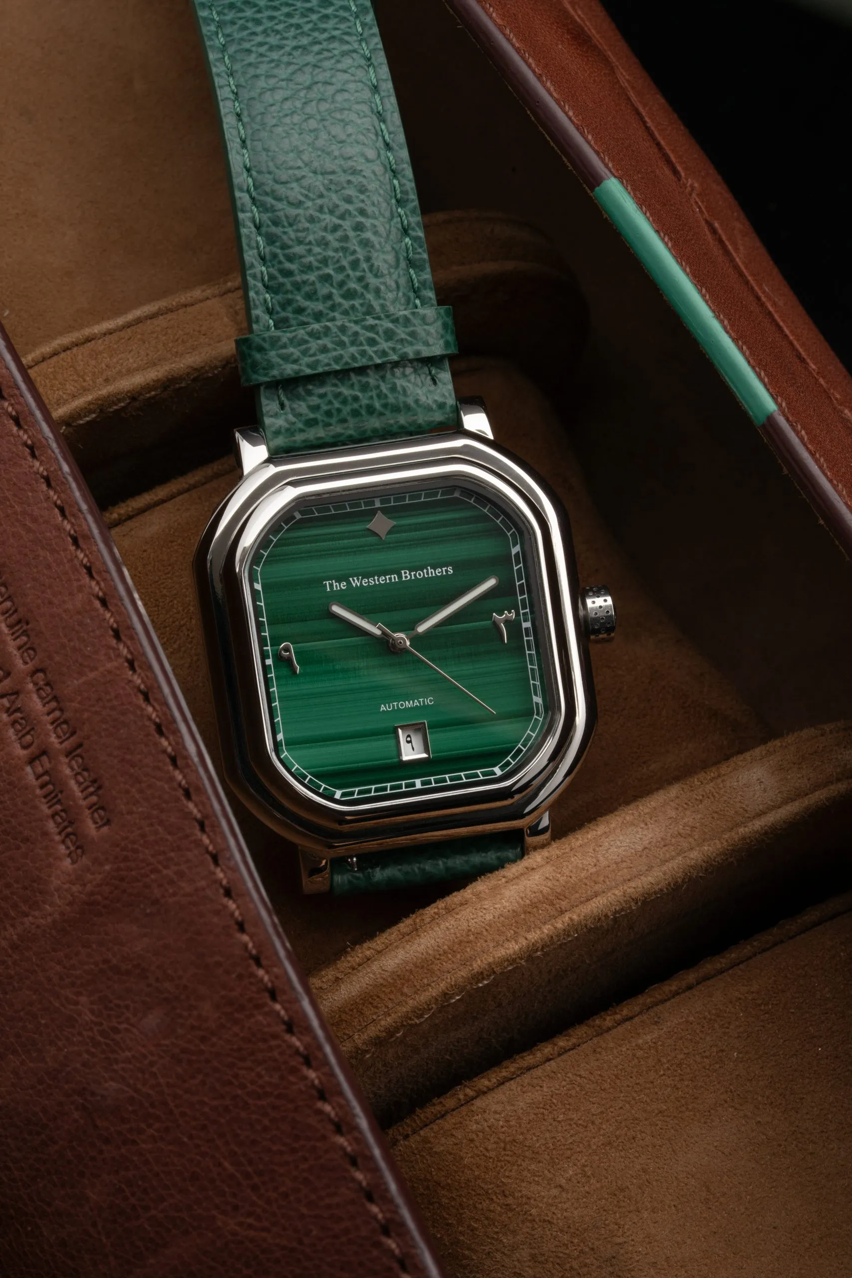 Green dial watch in a leather travel case