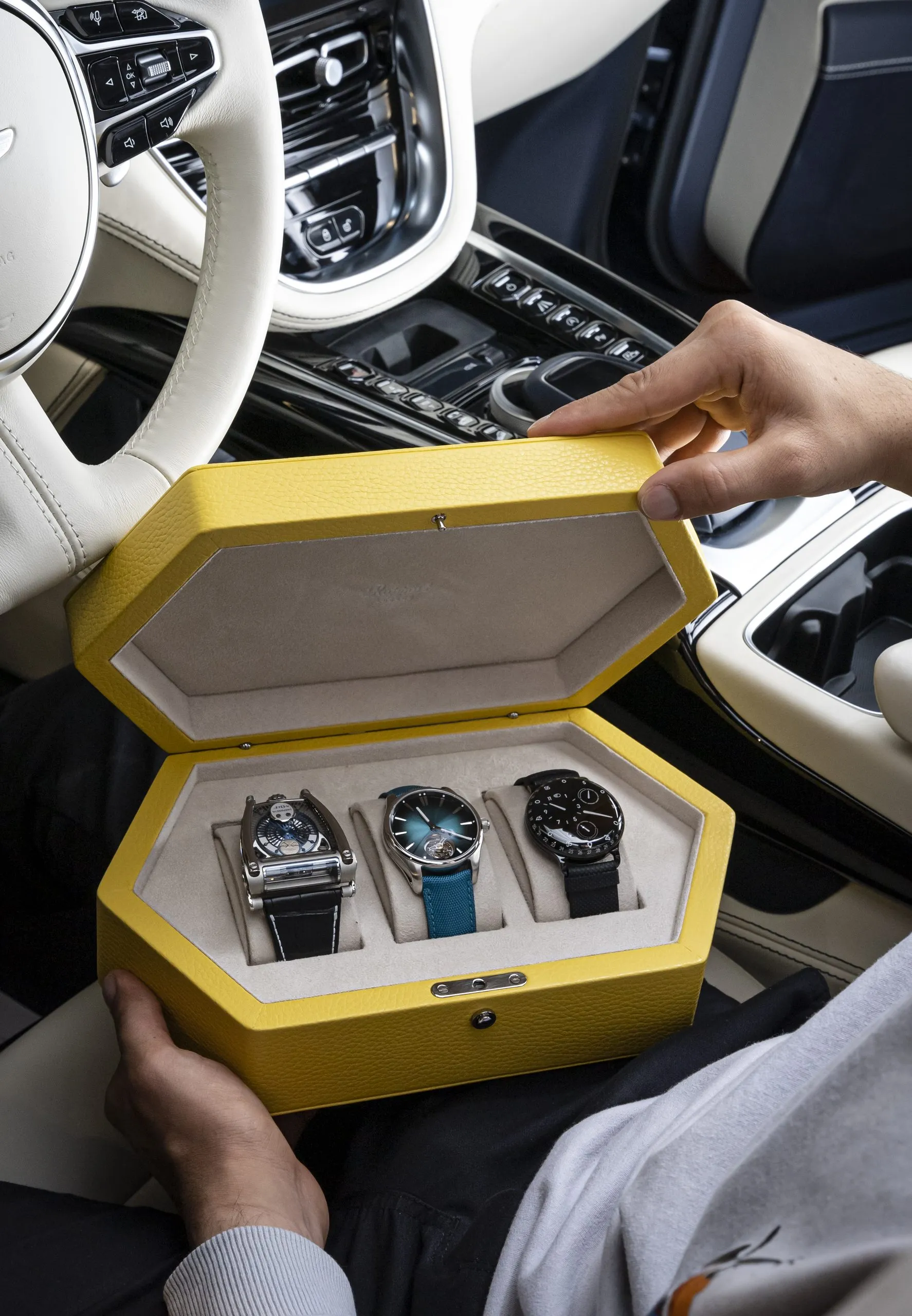 Open yellow watch case on the seat of a supercar