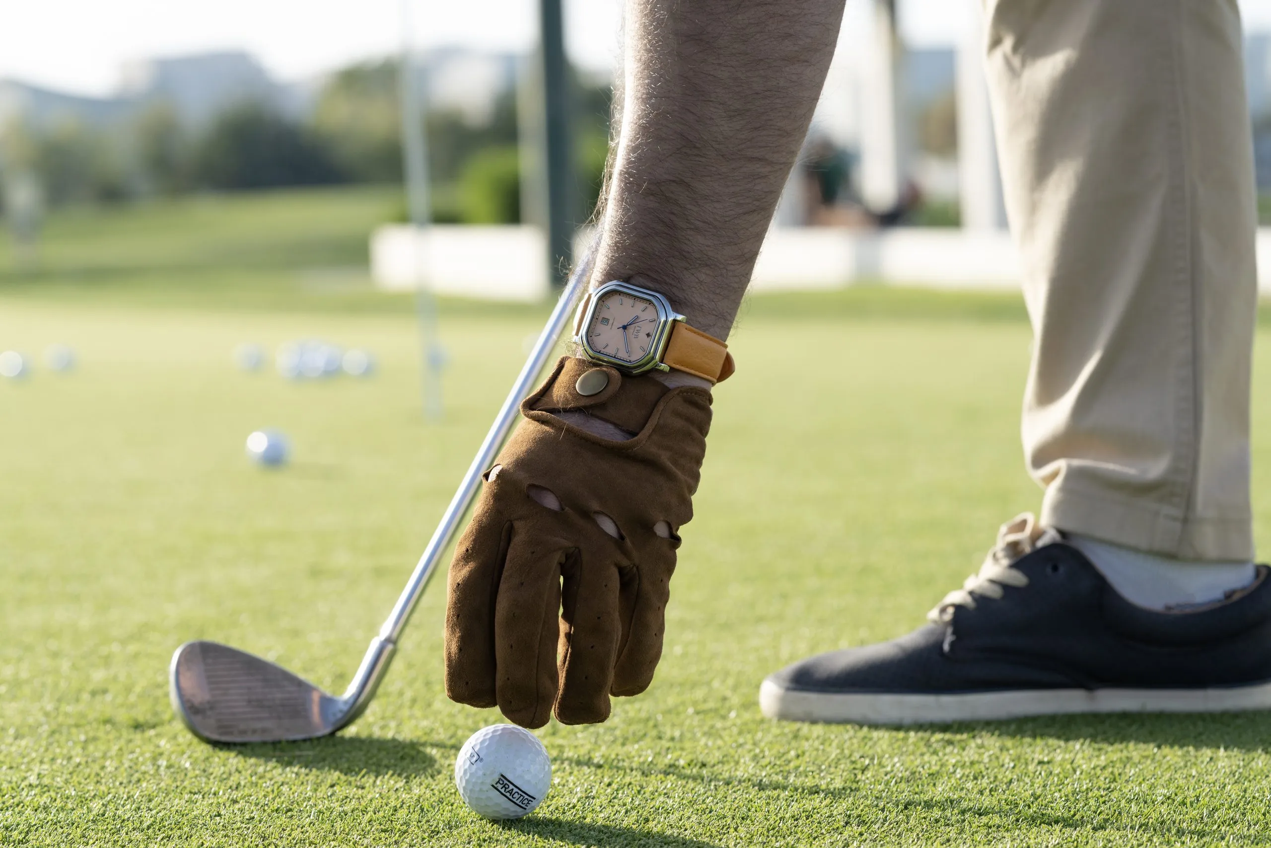 Golfer in a leather glove addressing the ball