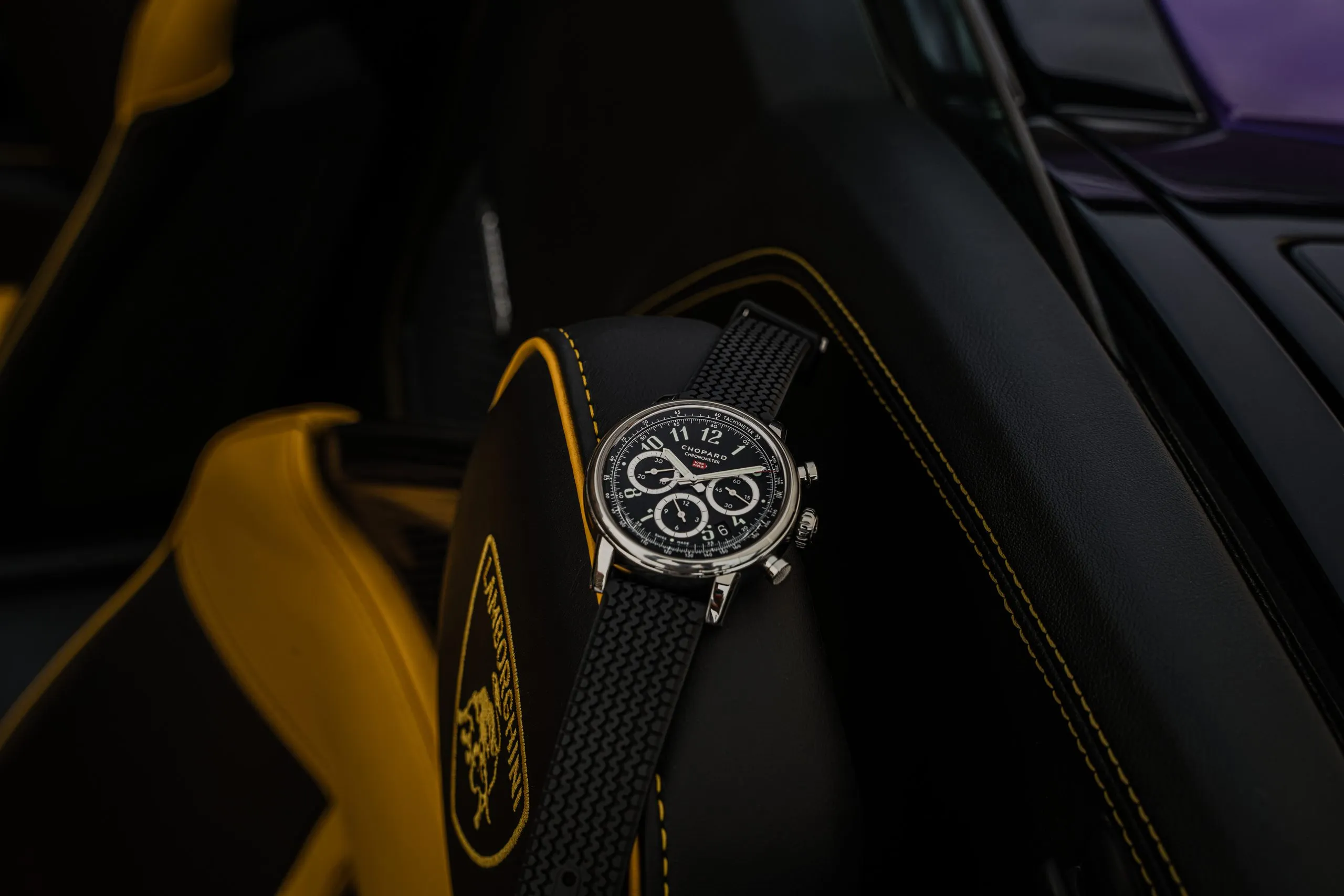 Black chronograph against yellow supercar bodywork