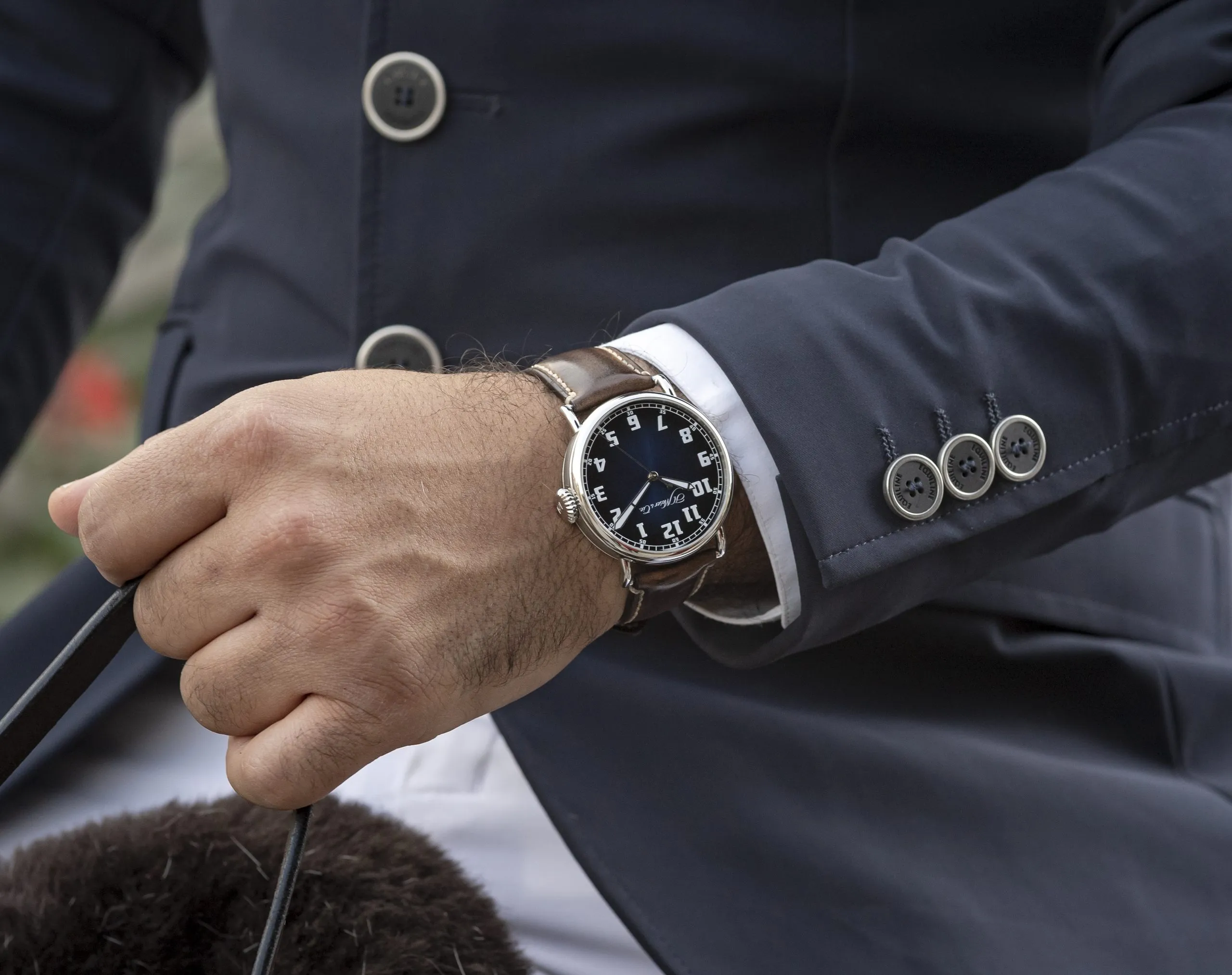 Silver watch on the wrist of a man in a navy suit