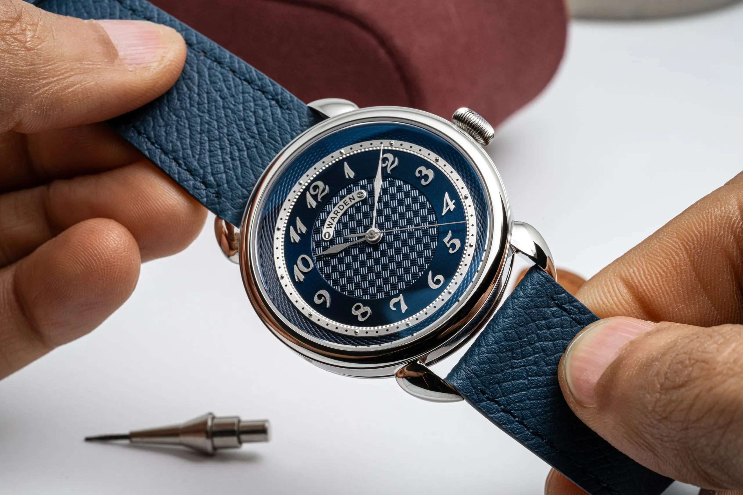 Blue dial watch standing on its strap
