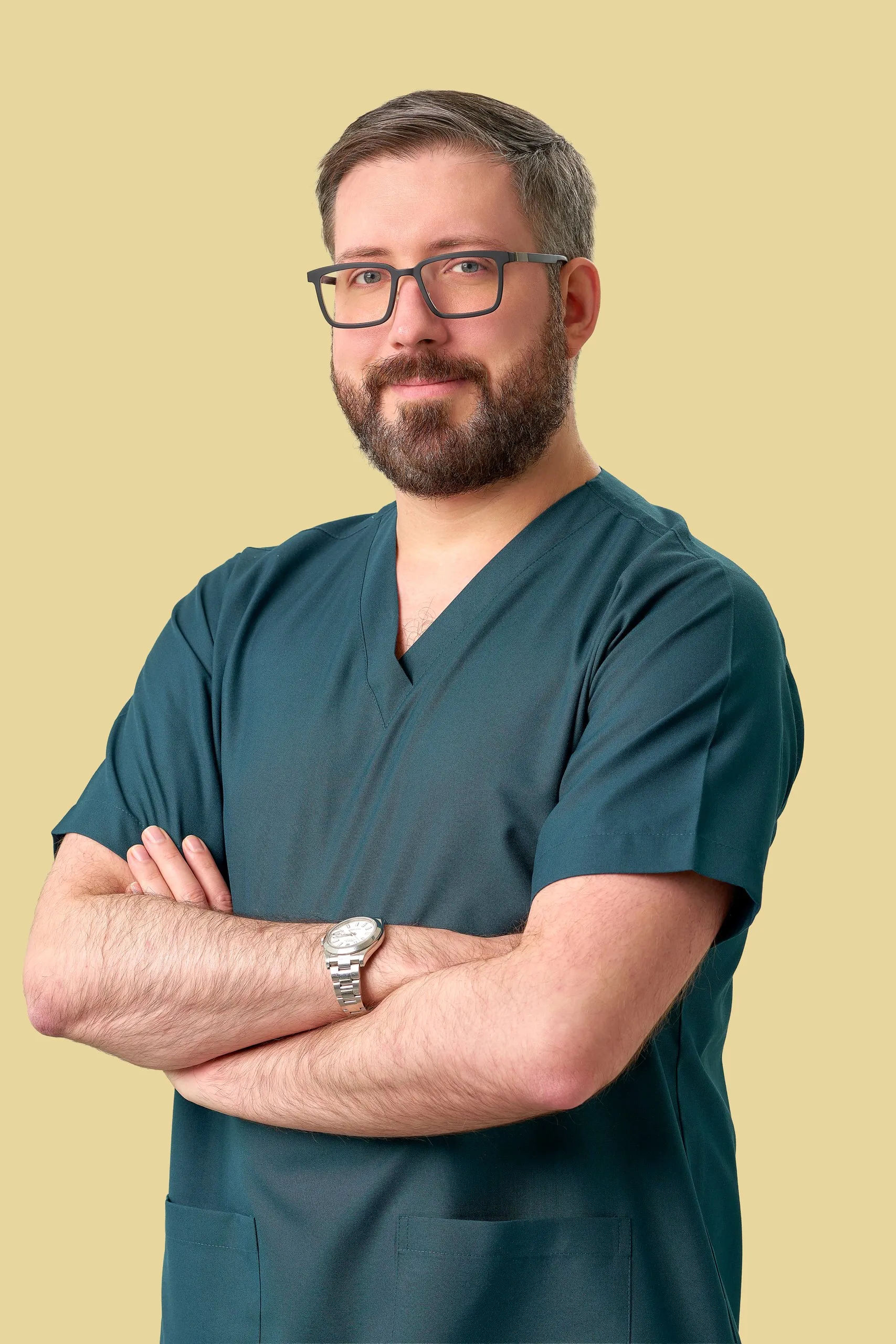 Doctor in teal scrubs, arms crossed