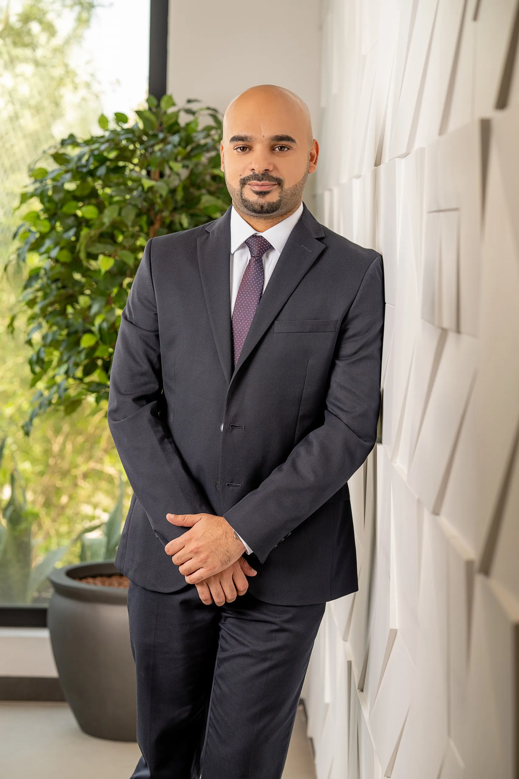 Businessman beside office greenery