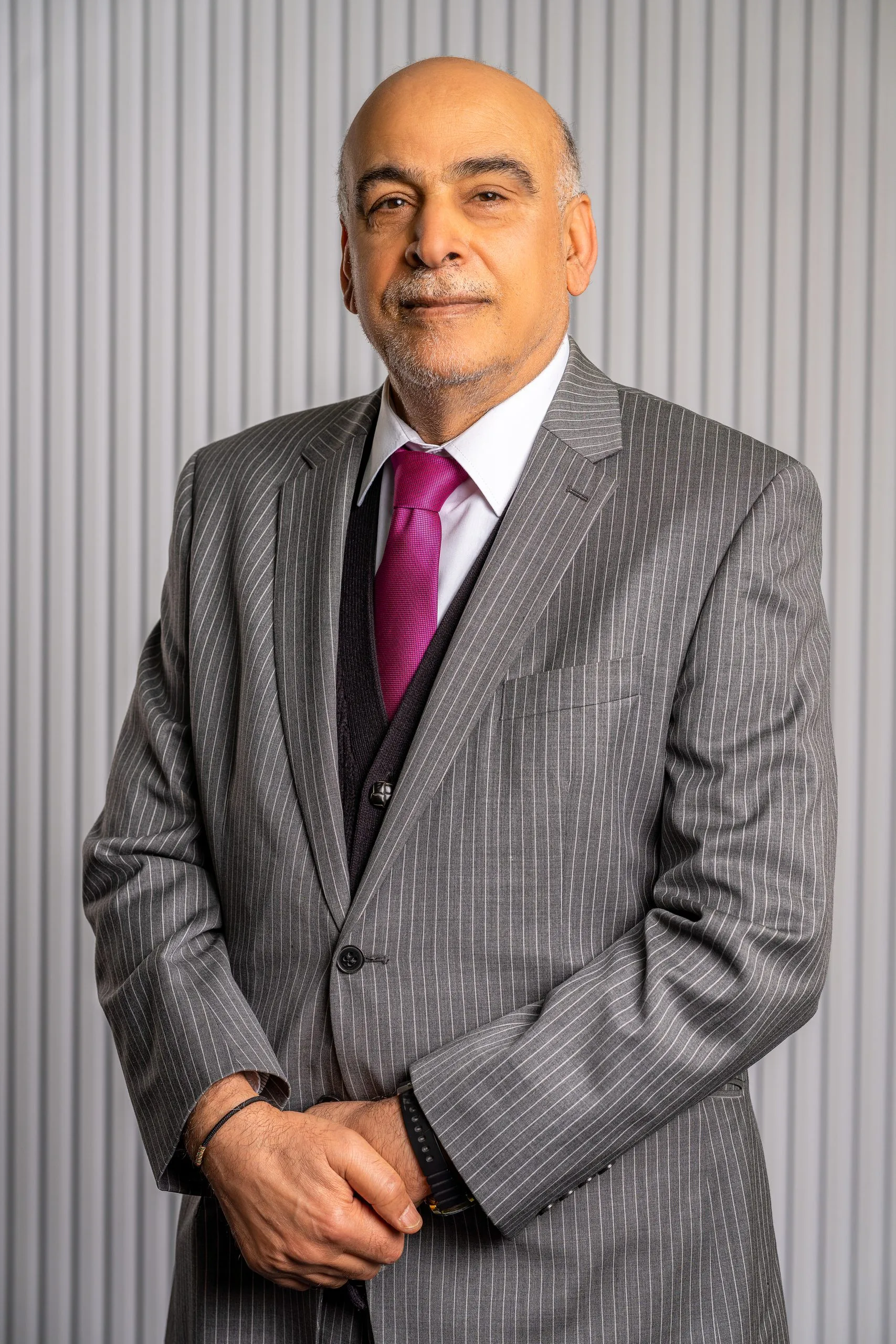 Executive in a grey suit and purple tie, studio portrait